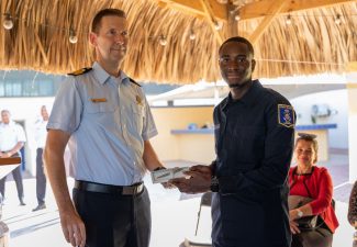 WILLEMSTAD - After successfully completing a year of training, twenty cadets received their coastguard certificate and diploma for Special Agent of the Police (BOA) last Friday from the Director of the Caribbean Coast Guard, Frank Boots and Alpha Falbru, Director of the Training Institute Law Enforcement and Security Care ( ORV). The cadets received the diploma and certificate during a ceremony at Naval Base Parera. The aspirants are now fully-fledged coastguards and will strengthen the coastguard support points on Curaçao, Sint Maarten and Aruba. These cadtes started the Coast Guard Basic Training (BOK) in August 2021. In the following four weeks they had their training weeks, the Samen Sterk period, in which they are tested both mentally and physically. After the training weeks, the rest of the BOK started and they received lessons in basic and shooting skills, seamanship, legal subjects, nautical subjects and boarding procedures. The aspirants have endured many physical, mental and theoretical challenges and are now ready to protect and help society. Hard work During the ceremony, the Director of the Coast Guard, Frank Boots and Alpha Falbru of the ORV addressed the new coast guards officers. The young cadets have been looking forward to this day for over a year. After working hard and being away from home for long periods, it is now time to celebrate. The diplomas are in and the real work at the Coast Guard can begin. The new coastguards will soon go to the coastguard bases where they will be deployed at sea together with the other coastguards officers.