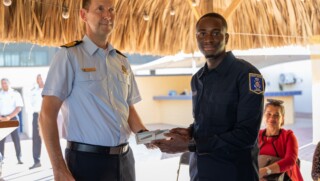 WILLEMSTAD - After successfully completing a year of training, twenty cadets received their coastguard certificate and diploma for Special Agent of the Police (BOA) last Friday from the Director of the Caribbean Coast Guard, Frank Boots and Alpha Falbru, Director of the Training Institute Law Enforcement and Security Care ( ORV). The cadets received the diploma and certificate during a ceremony at Naval Base Parera. The aspirants are now fully-fledged coastguards and will strengthen the coastguard support points on Curaçao, Sint Maarten and Aruba. These cadtes started the Coast Guard Basic Training (BOK) in August 2021. In the following four weeks they had their training weeks, the Samen Sterk period, in which they are tested both mentally and physically. After the training weeks, the rest of the BOK started and they received lessons in basic and shooting skills, seamanship, legal subjects, nautical subjects and boarding procedures. The aspirants have endured many physical, mental and theoretical challenges and are now ready to protect and help society. Hard work During the ceremony, the Director of the Coast Guard, Frank Boots and Alpha Falbru of the ORV addressed the new coast guards officers. The young cadets have been looking forward to this day for over a year. After working hard and being away from home for long periods, it is now time to celebrate. The diplomas are in and the real work at the Coast Guard can begin. The new coastguards will soon go to the coastguard bases where they will be deployed at sea together with the other coastguards officers.